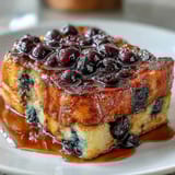 Blueberry Sourdough French Toast Bake with golden custard and juicy berries in a cozy baking dish.  