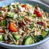 Vibrant orzo salad bursts with fresh cucumber, feta, and zesty lemon dressing.