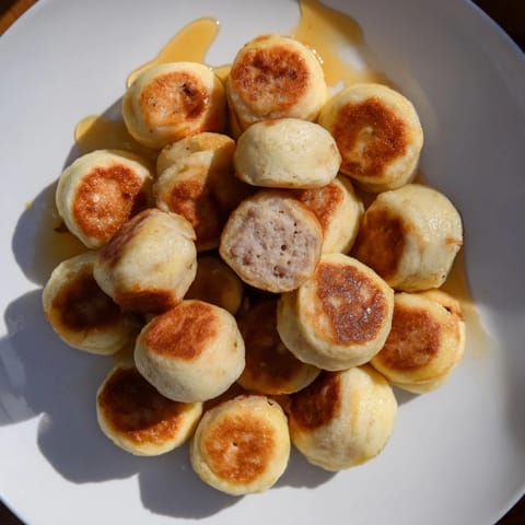 Mini Pancake Bites, perfectly spherical, with a fluffy interior and fruit bursting from their centers.
