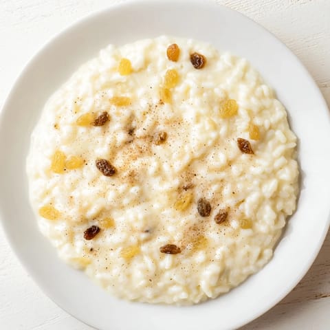 Golden baked rice pudding, dotted with plump raisins, offering a sweet & comforting flavor.