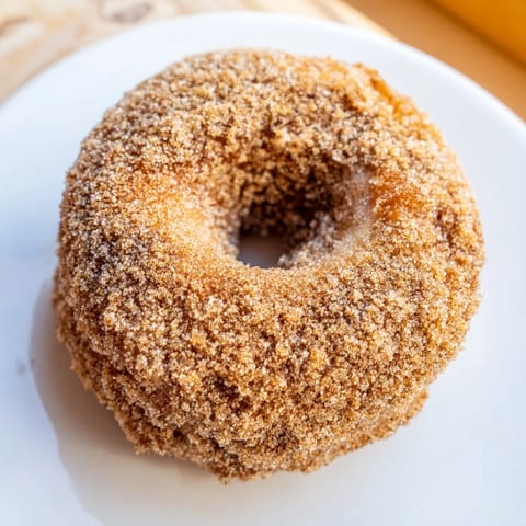 Warm, freshly made Apple Cider Donuts glistening with cinnamon sugar, perfect for fall breakfasts.