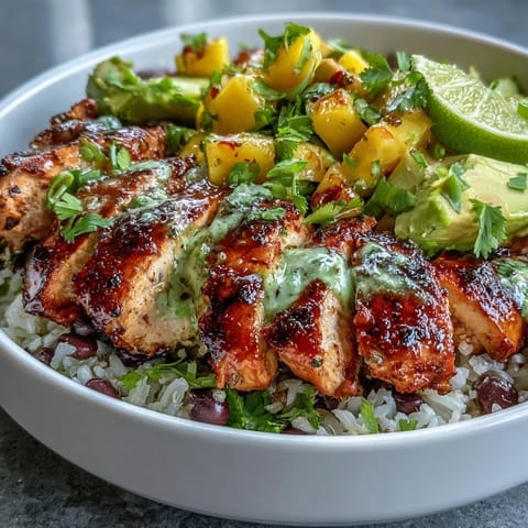 Wholesome chicken and black bean bowl with mango avocado salsa, served over fluffy brown rice for a nourishing meal.  