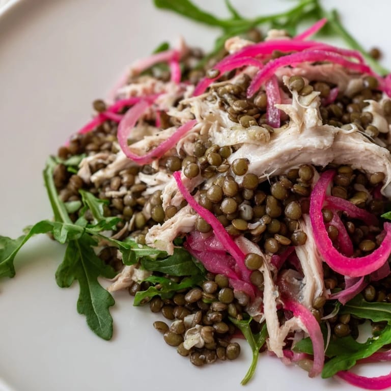 Fresh Lentil & Chicken Spring Salad served in a white bowl, drizzled with mustard dressing, perfect for spring lunches.