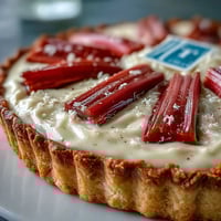 Golden roasted rhubarb batons glisten atop the creamy white chocolate and elderflower tart, nestled against the crisp, buttery crust.  